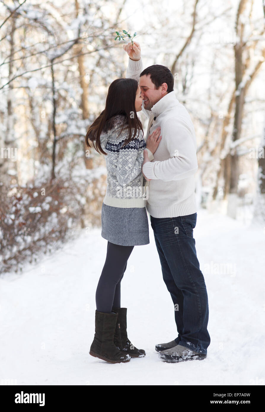 Happy young couple having fun in the winter park Stock Photo - Alamy