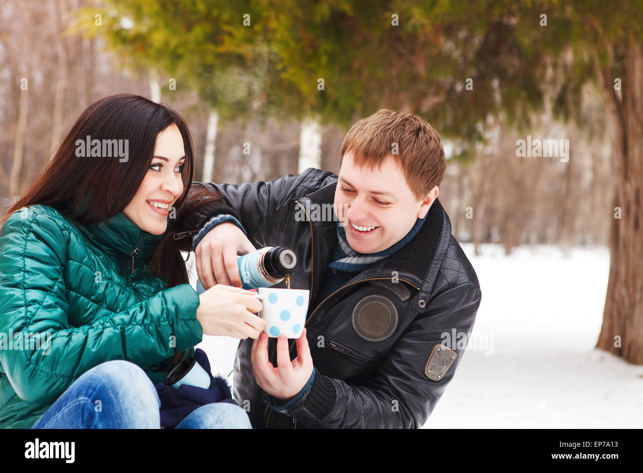Happy young couple having fun in the winter park Stock Photo - Alamy