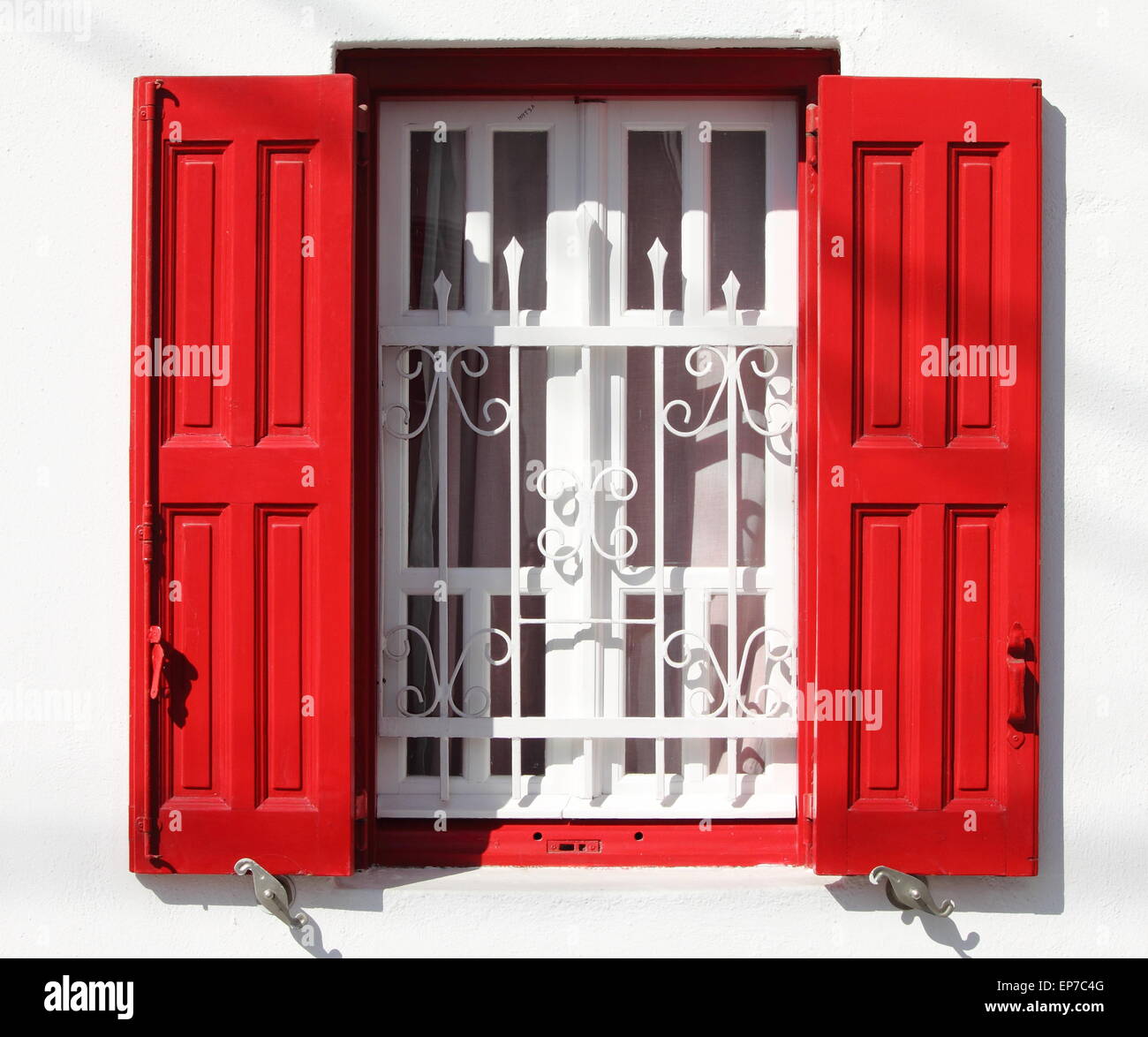 Beautiful window with grille and red shutters in Greece Stock Photo Alamy
