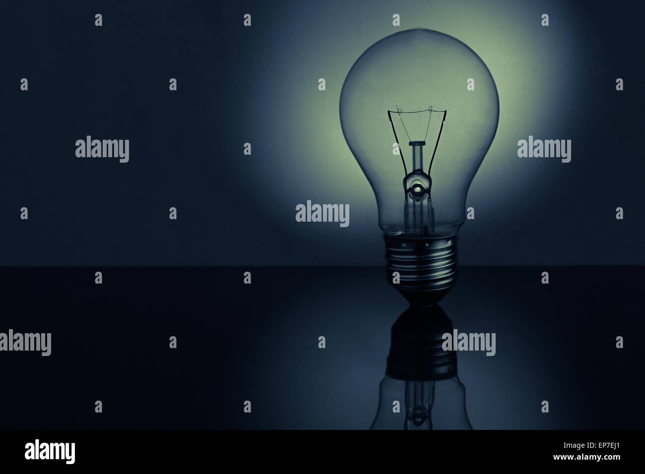 Light bulb standing on bright reflective surface Stock Photo Alamy