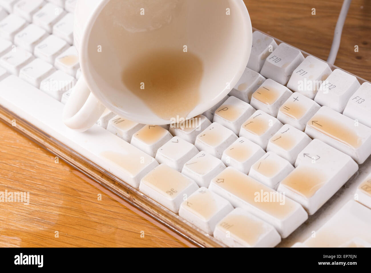 Cup of tea spilled out over a keyboard close up Stock Photo - Alamy