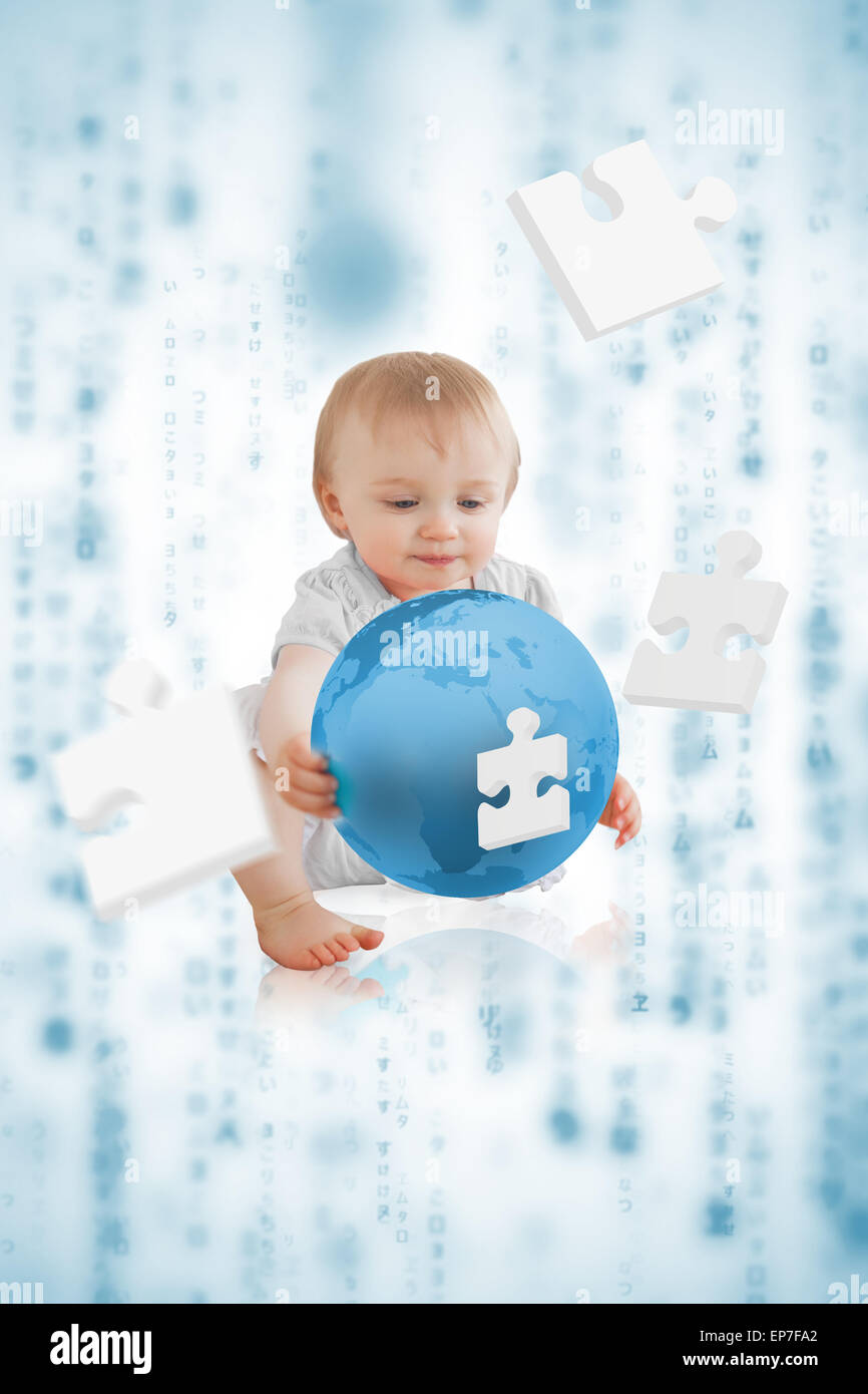 Cute baby holding a blue planet with jigsaw pieces floating around him Stock Photo