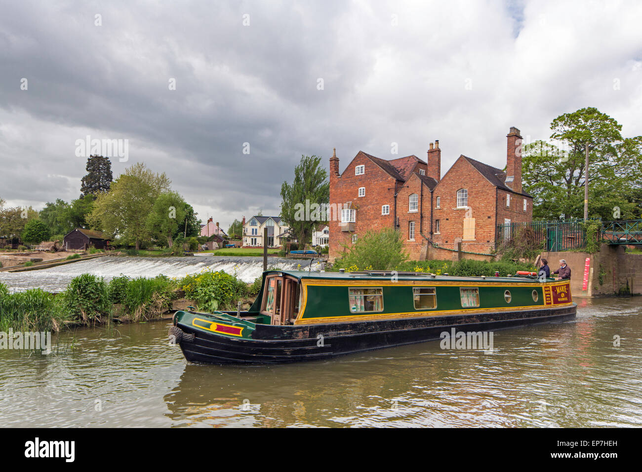 A narrowboat leaving Fladbury Lock on the River Avon with Cropthorne