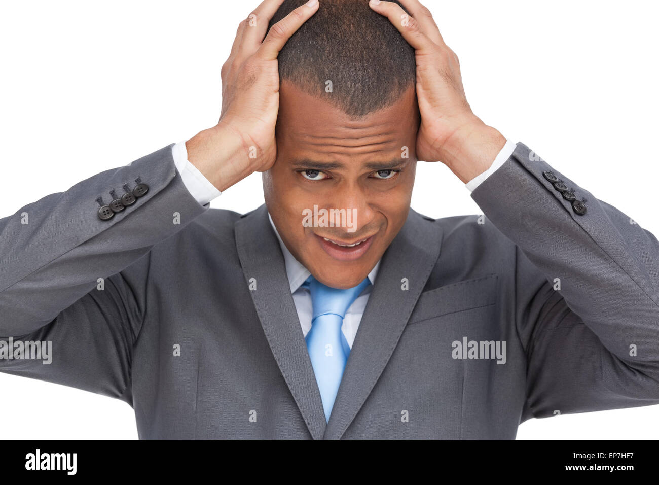 Exhausted young businessman holding his head between hands Stock Photo ...