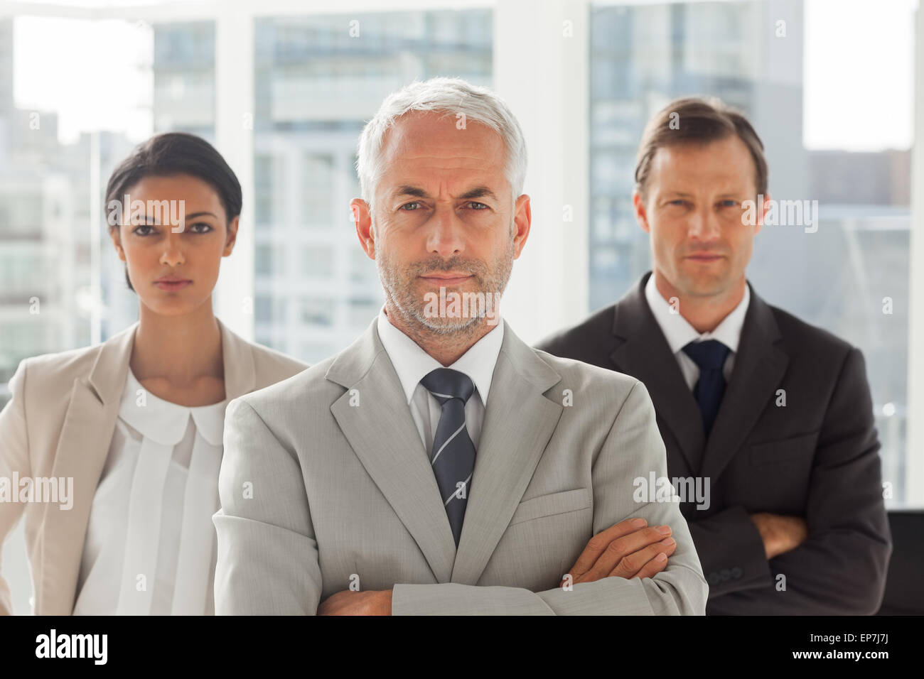 Serious businessman standing with colleagues behind Stock Photo - Alamy