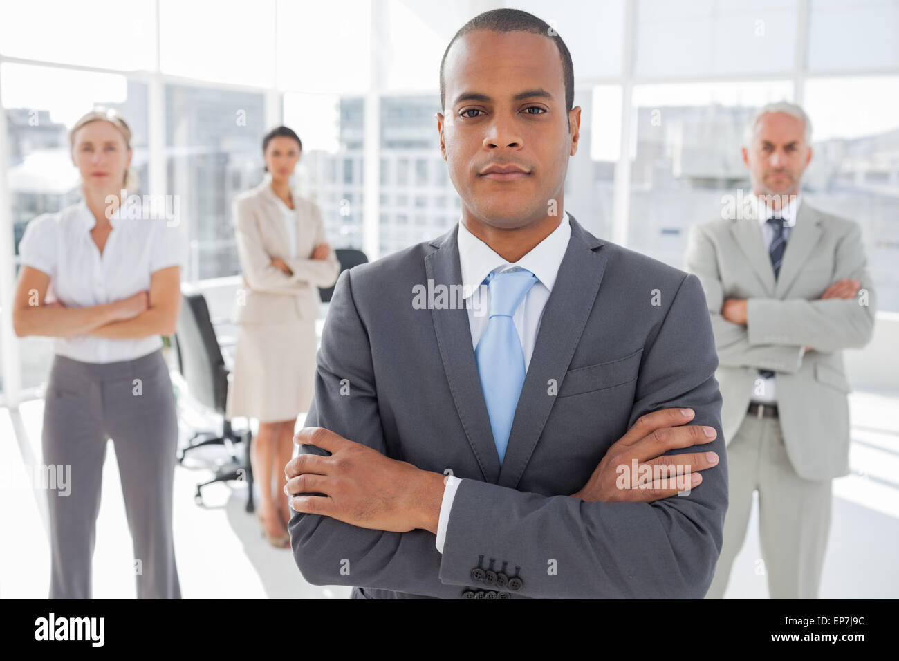 Serious businessman standing with arms crossed Stock Photo - Alamy