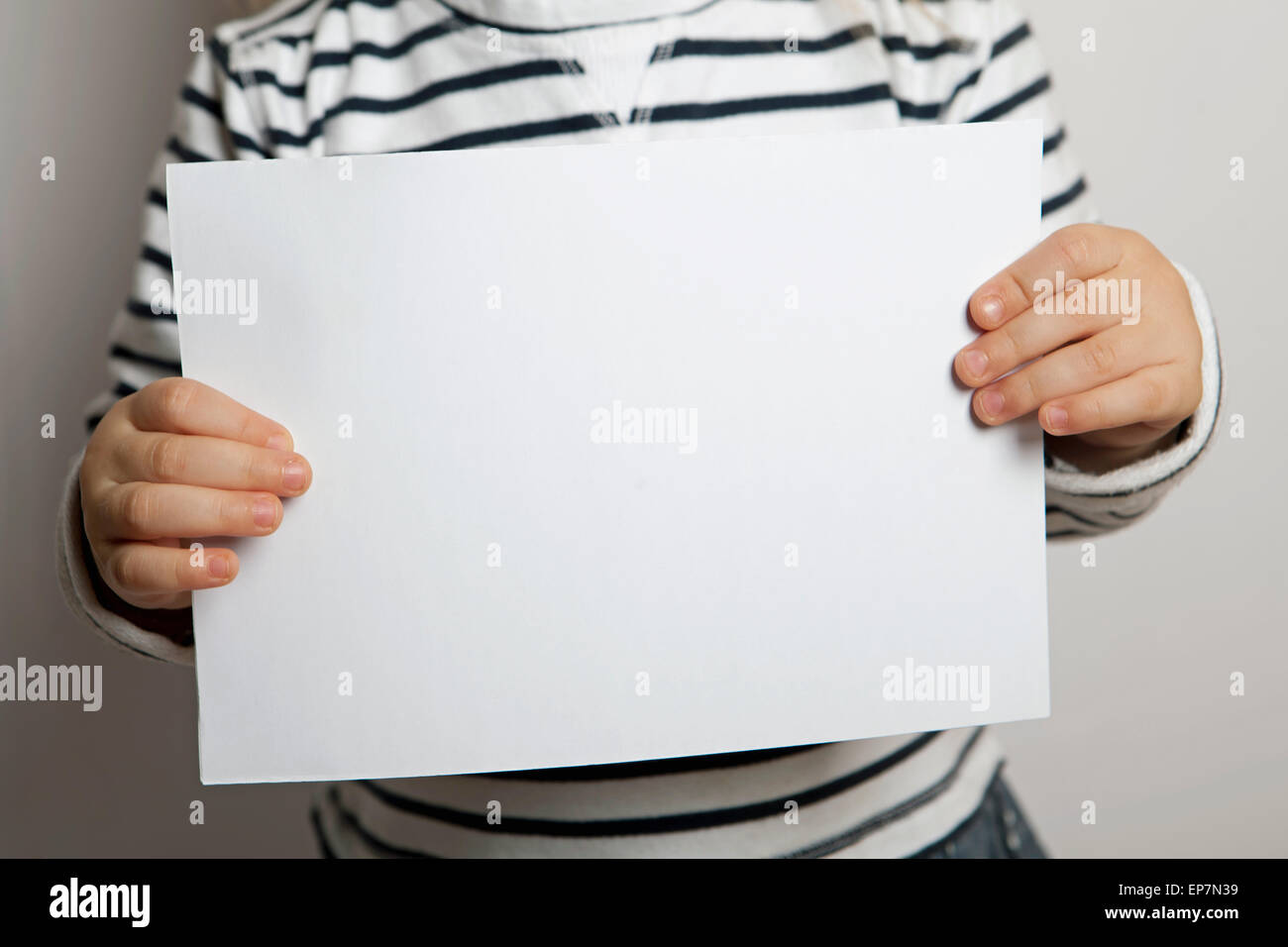 Blank sheet of paper in child's hands Stock Photo