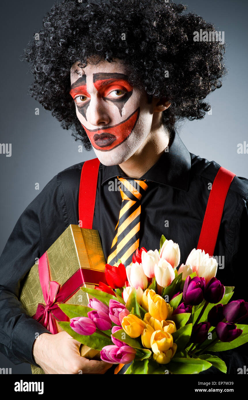 Sad clown with the flowers Stock Photo