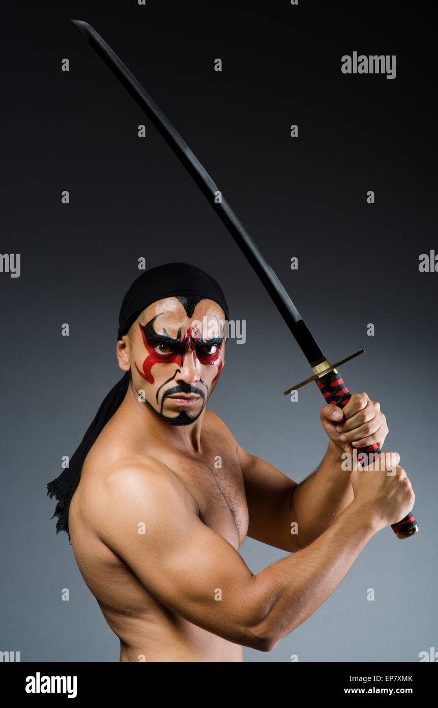 Man with sword and face paint Stock Photo