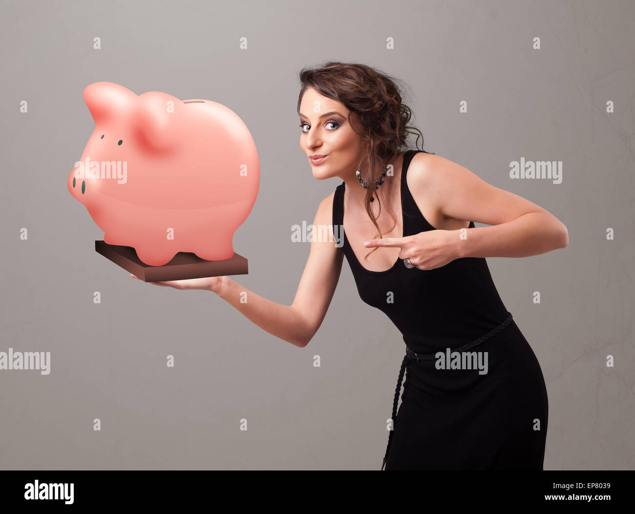 Young girl holding a huge savings piggy bank Stock Photo - Alamy