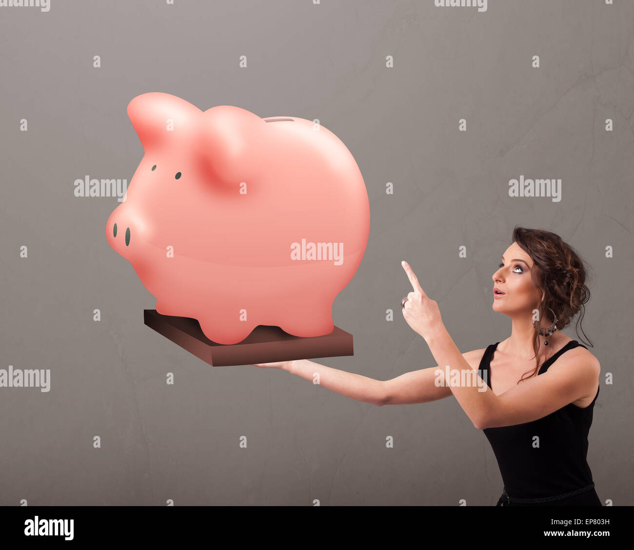 Young girl holding a huge savings piggy bank Stock Photo - Alamy