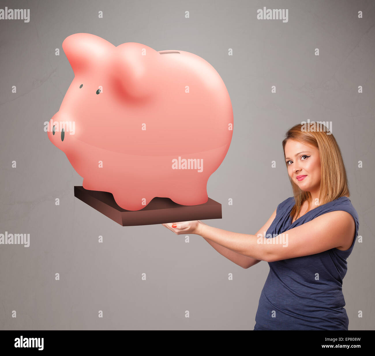 Young girl holding a huge savings piggy bank Stock Photo - Alamy