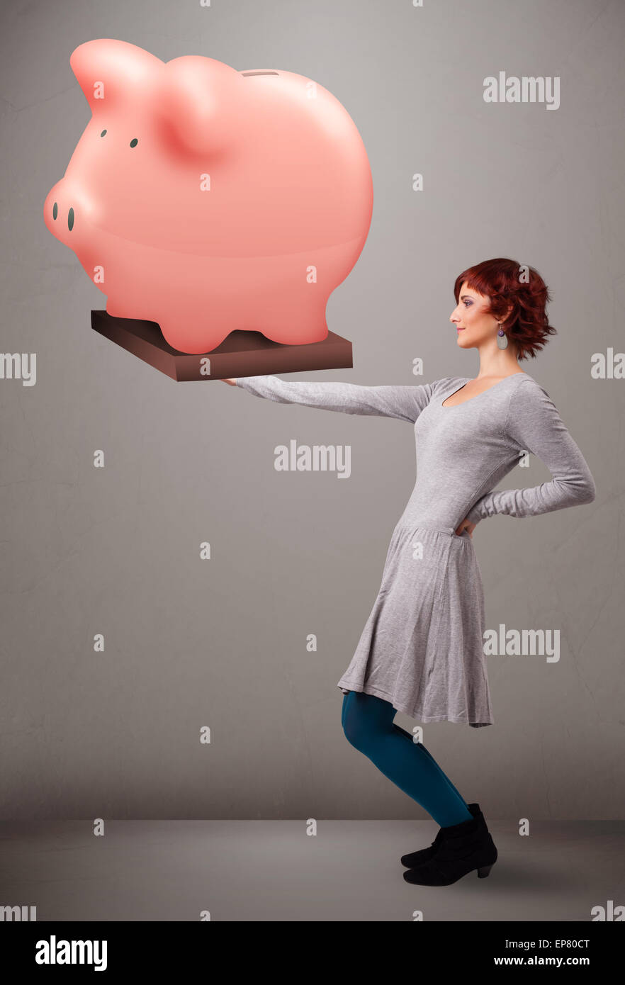 Young girl holding a huge savings piggy bank Stock Photo - Alamy