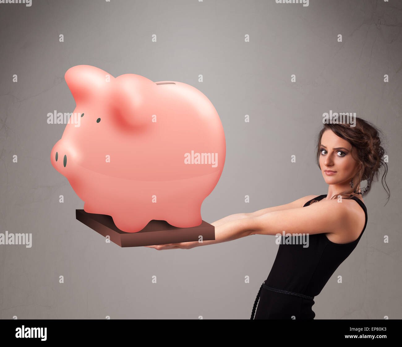 Young girl holding a huge savings piggy bank Stock Photo - Alamy