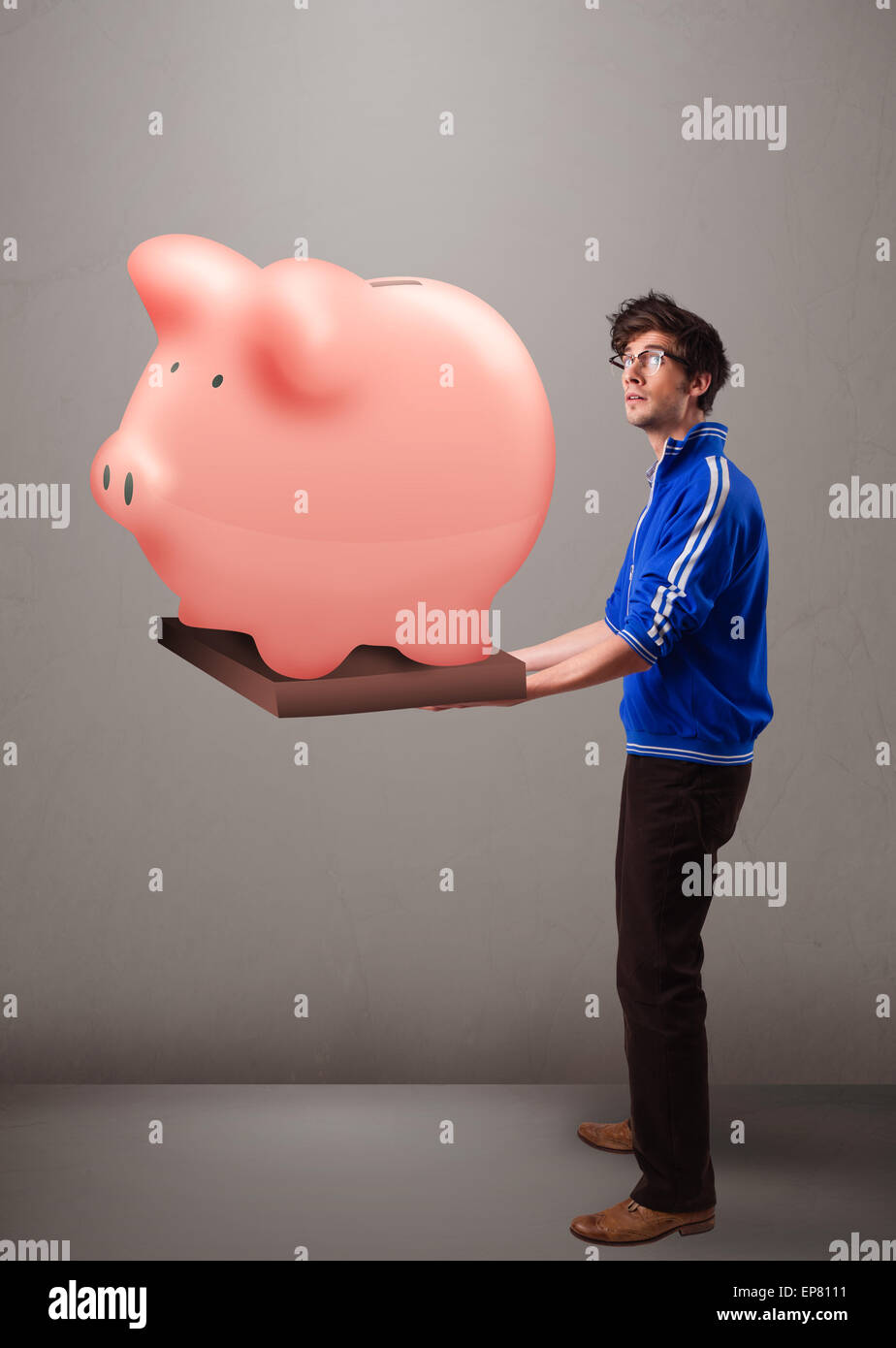 Handsome man holding a huge savings piggy bank Stock Photo - Alamy