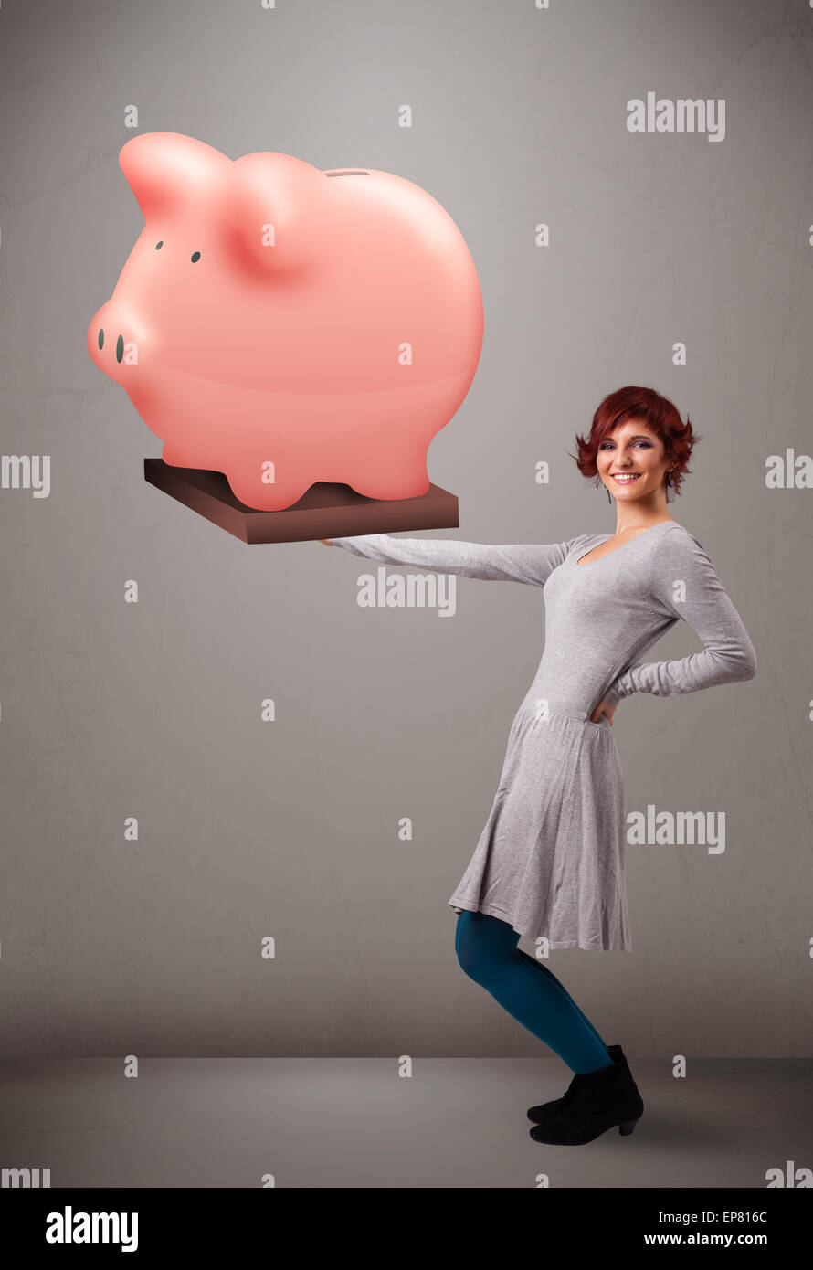 Young girl holding a huge savings piggy bank Stock Photo - Alamy