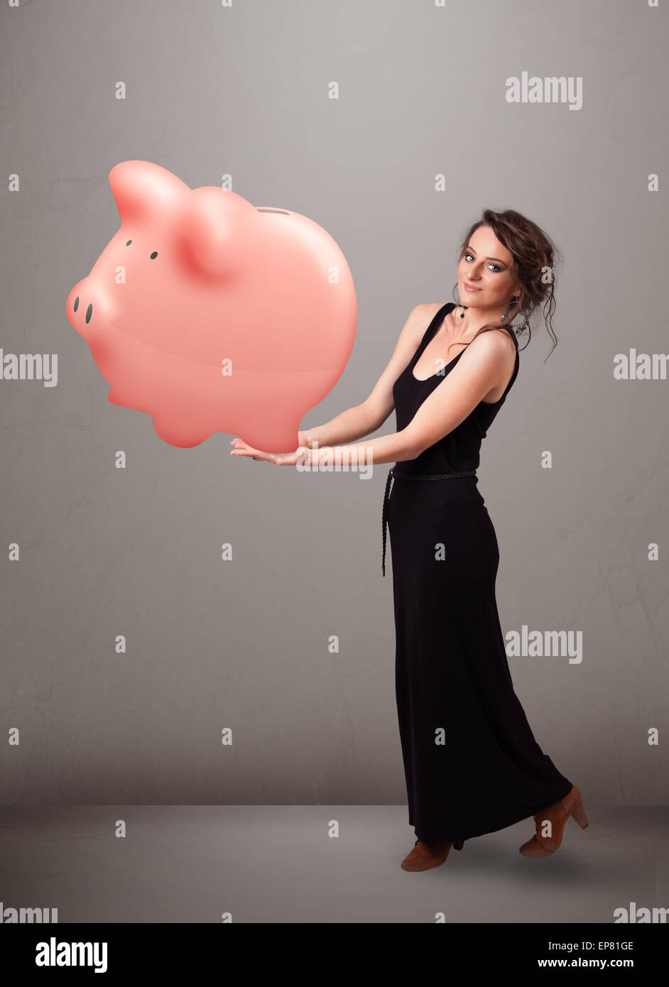 Young girl holding a huge savings piggy bank Stock Photo - Alamy