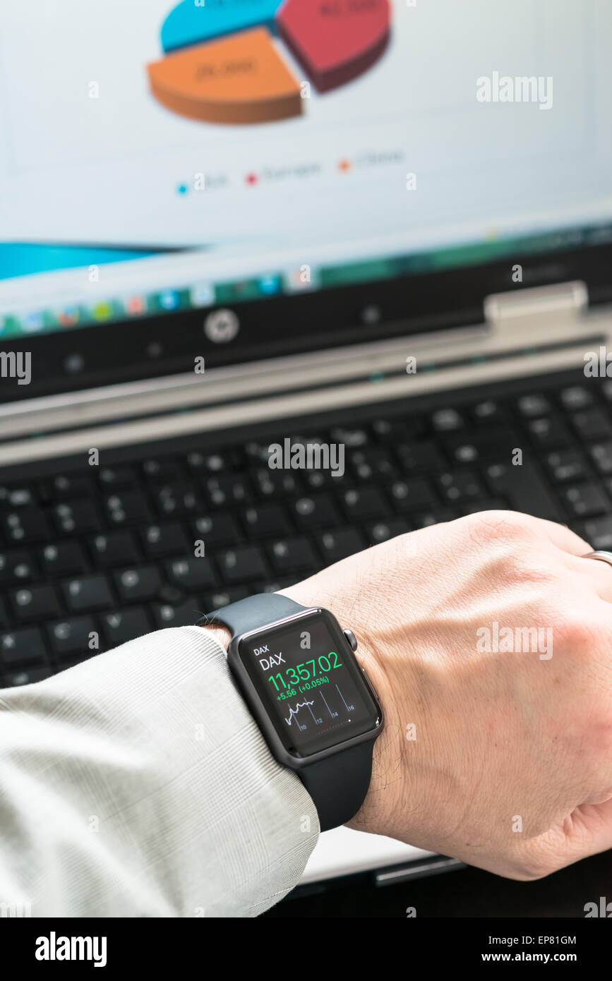 OSTFILDERN, GERMANY - MAY 14, 2015: A businessman is checking stock market prices using his black Apple Watch Sport while creati Stock Photo