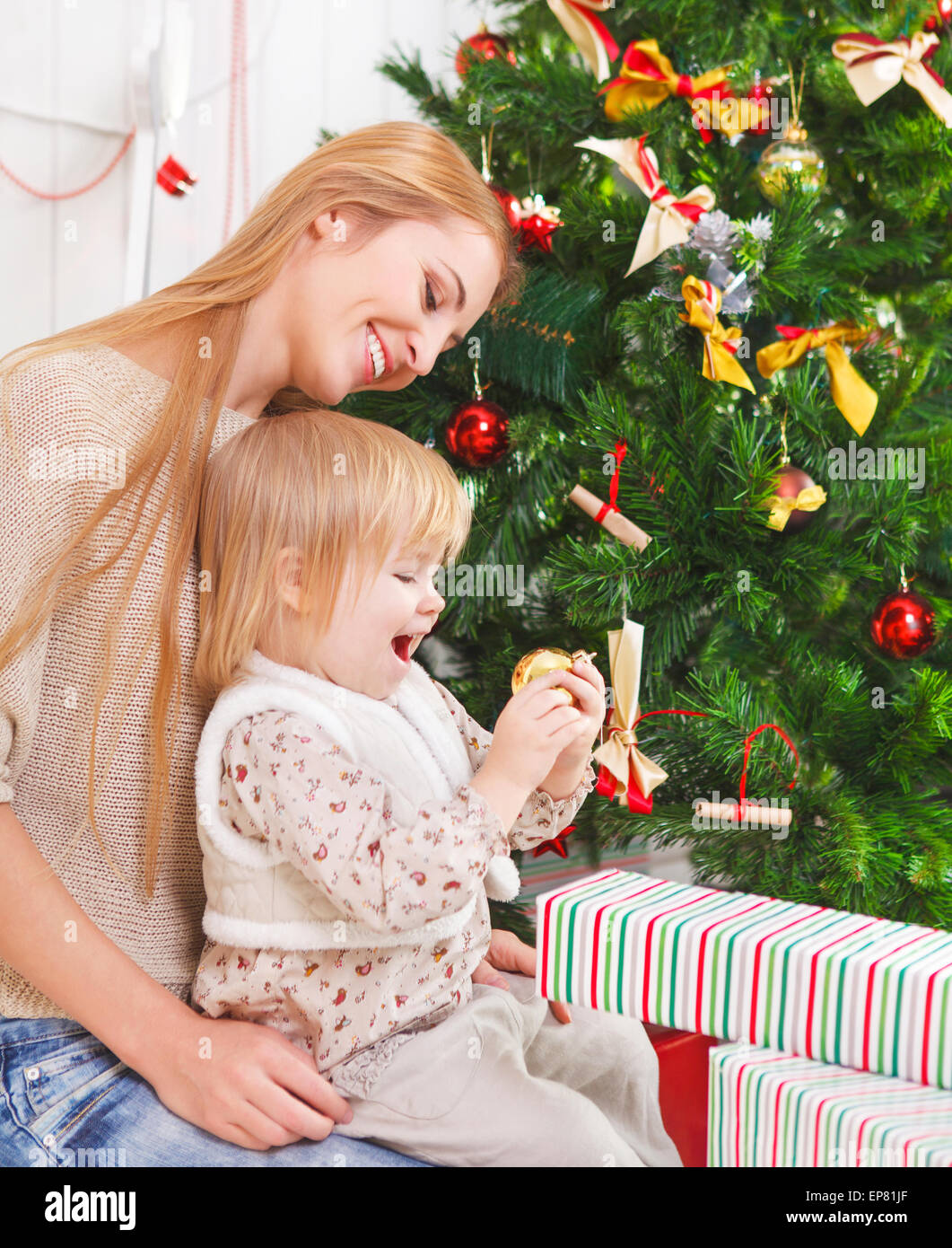 Mother with her little daughter under the Christmas tree Stock Photo ...