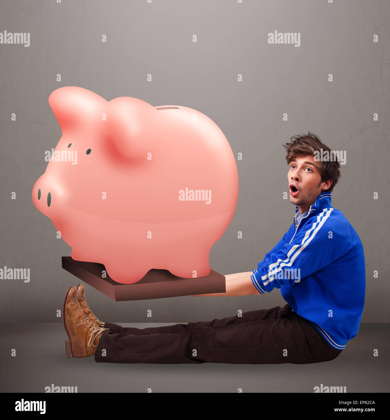 Handsome man holding a huge savings piggy bank Stock Photo - Alamy