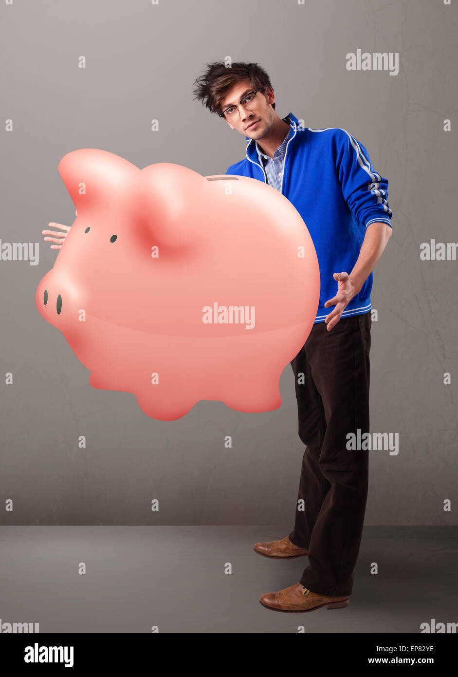 Handsome man holding a huge savings piggy bank Stock Photo - Alamy