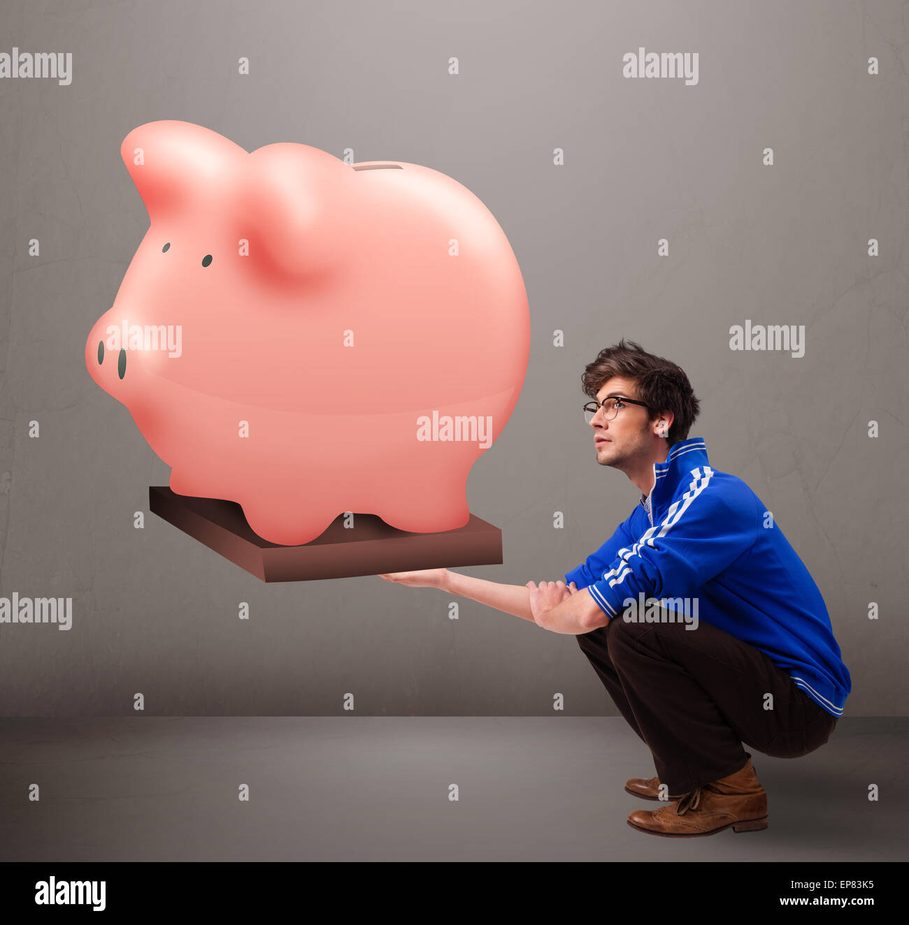 Handsome man holding a huge savings piggy bank Stock Photo - Alamy