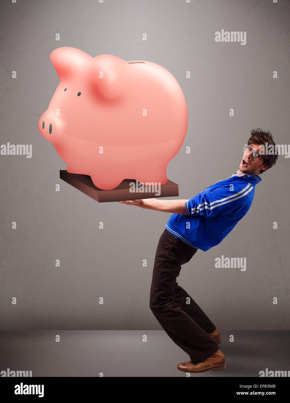Handsome man holding a huge savings piggy bank Stock Photo - Alamy