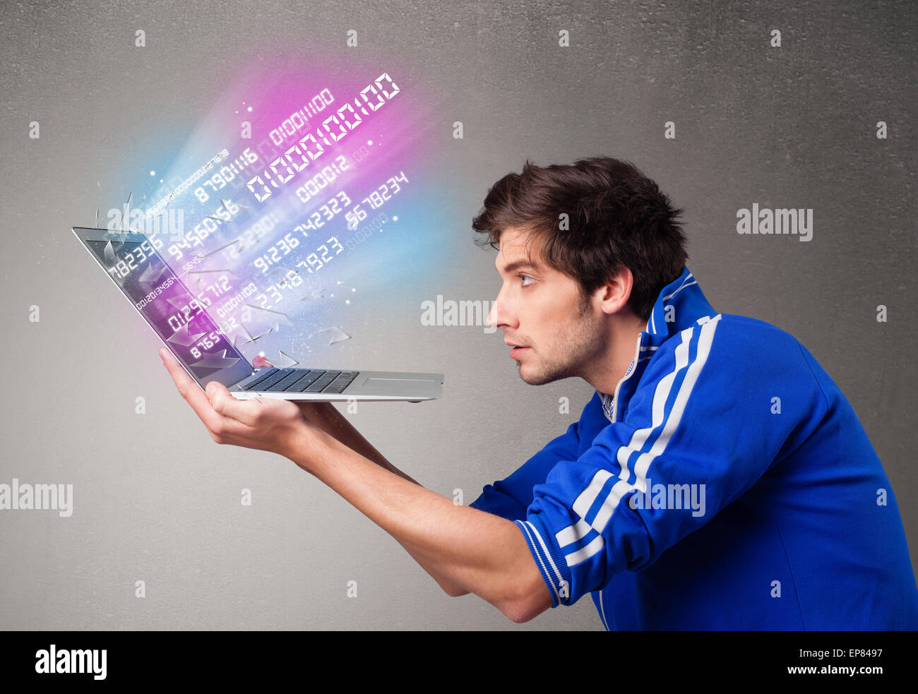 Casual man holding laptop with exploding data and numbers Stock Photo ...