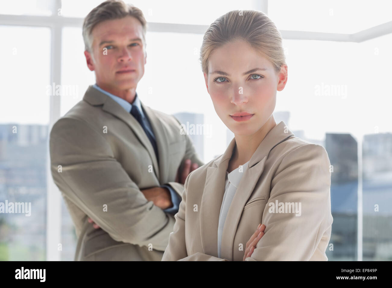 Serious business people standing with their arms crossed Stock Photo ...