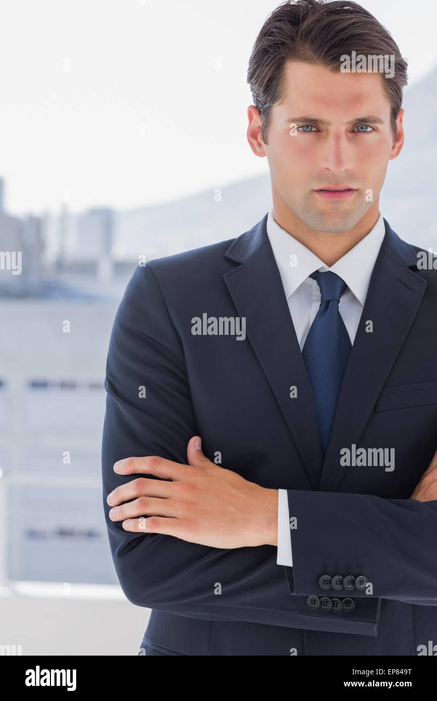 Handsome businessman standing with arms crossed Stock Photo - Alamy