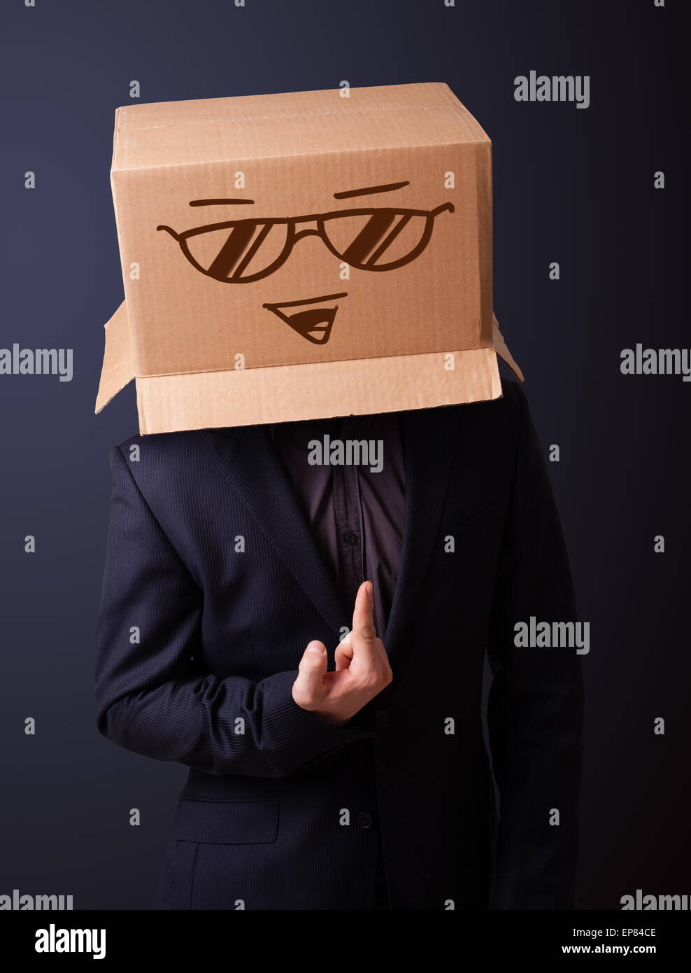 Young man gesturing with a cardboard box on his head with smiley face ...