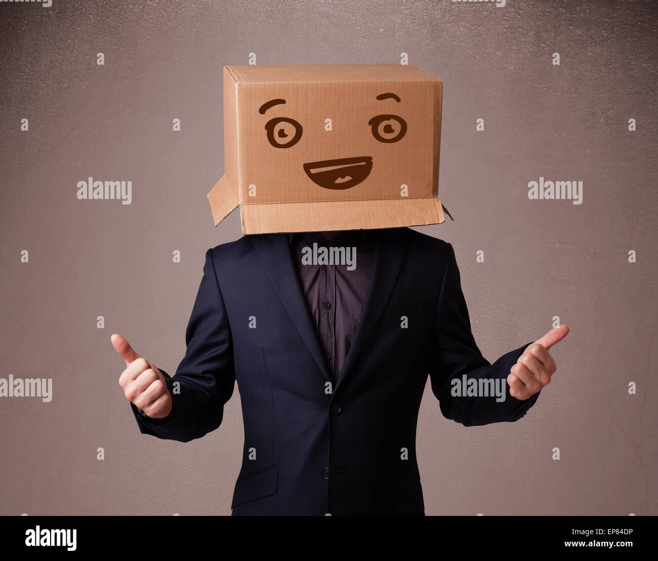 Young man gesturing with a cardboard box on his head with smiley face ...