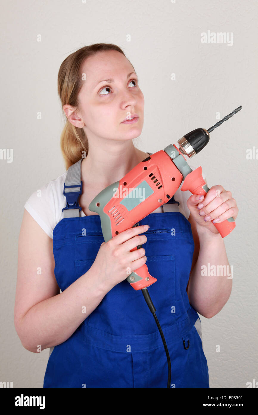 Junge Frau mit einem Bohrer in der Hand Stock Photo