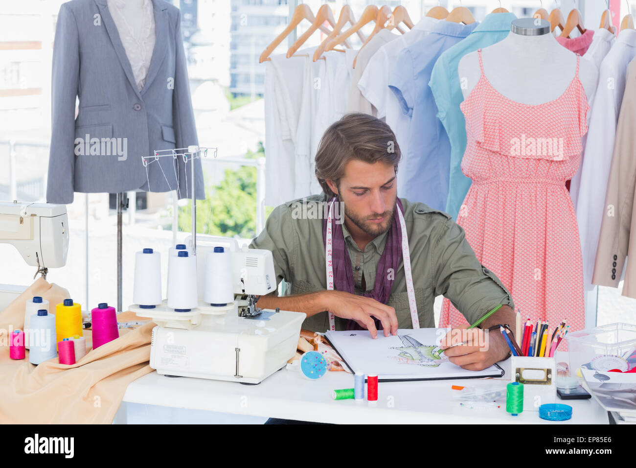 Handsome fashion designer drawing with pencils Stock Photo - Alamy