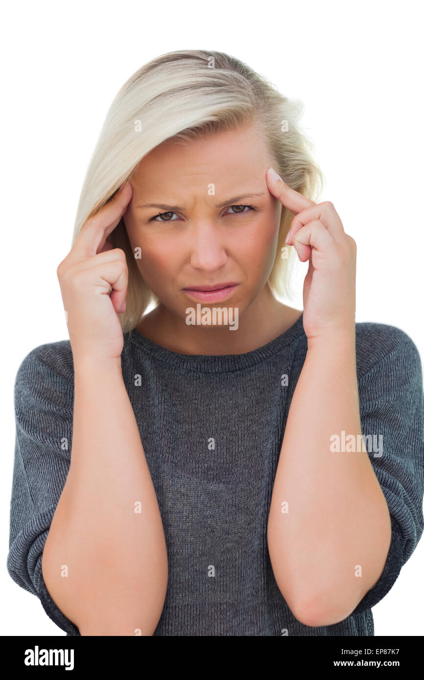 Woman with headache touching her forehead and looking at camera Stock
