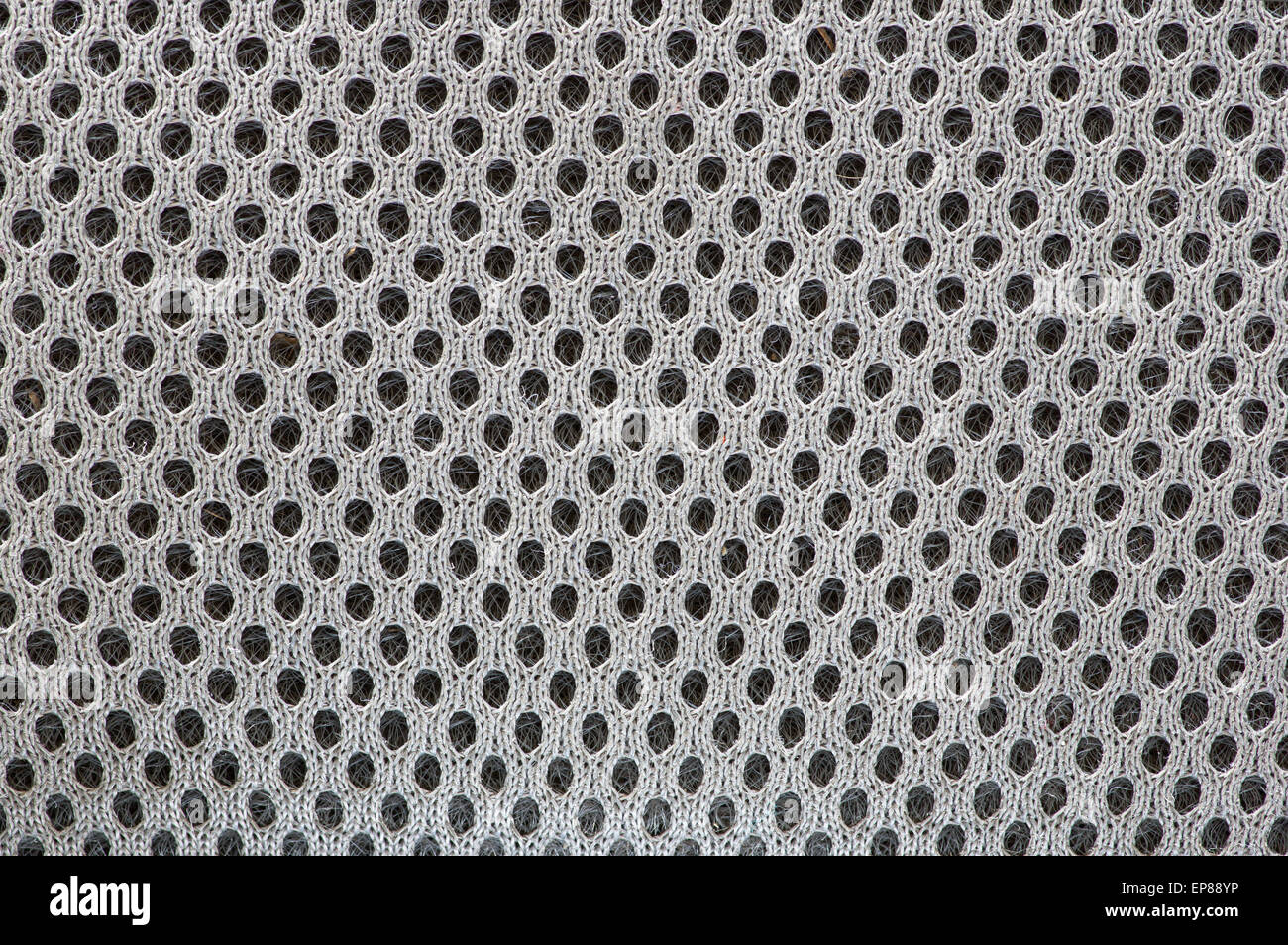 macro image of open textured woven fabric showing the individual threads and holes as a background Stock Photo