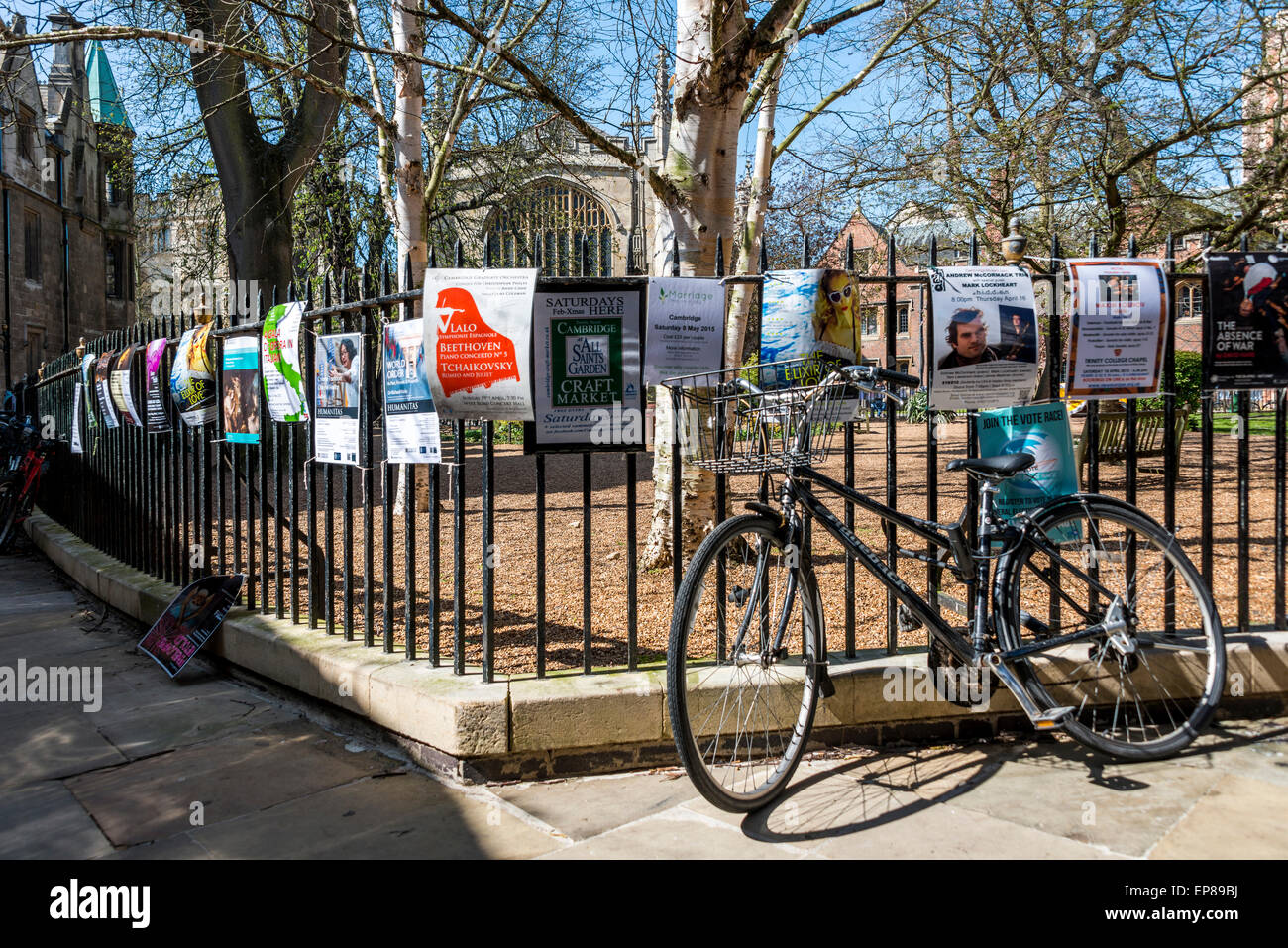 A bicycle parked against the railings of All Saints Garden on together with event fliers in the town centre of Cambridge Stock Photo