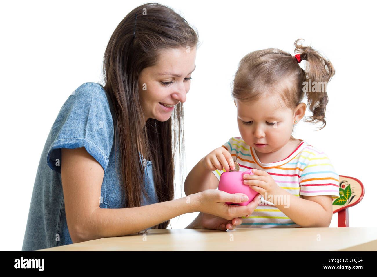 Mother and daughter put coins into piggy bank Stock Photo - Alamy