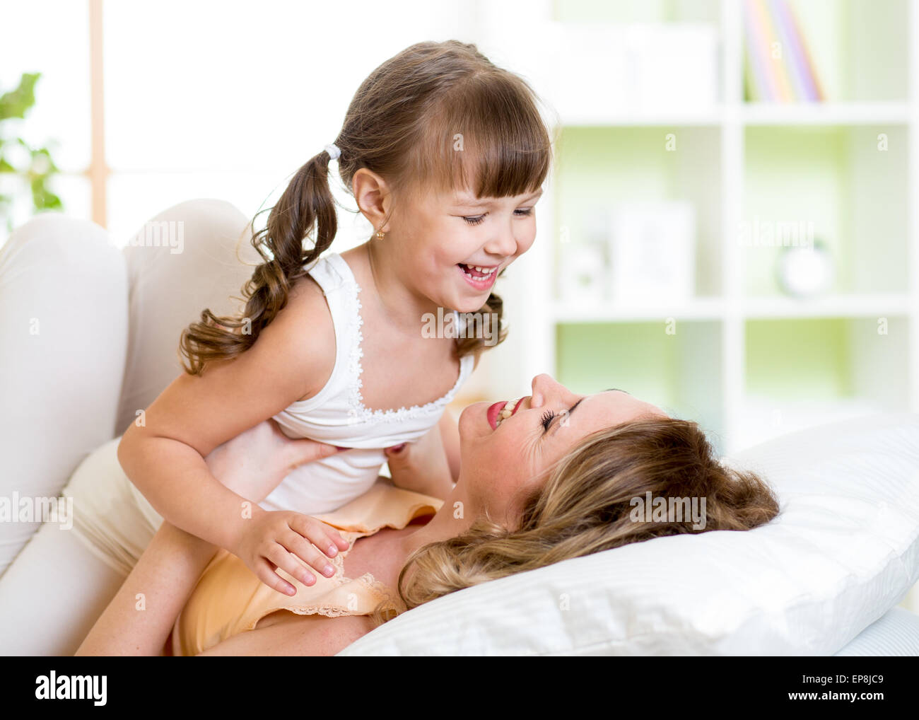 Mom and child having fun in bed Stock Photo