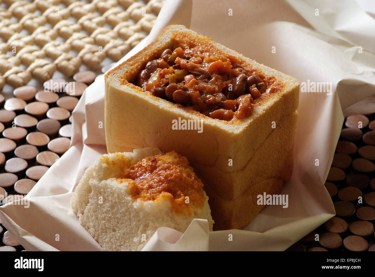 Bunny chow is a meal found exclsively in South Africa and it has its origins in Durban Kwa zulu Natal it is curry served in half loaf of fresh dug out white bread Stock Photo