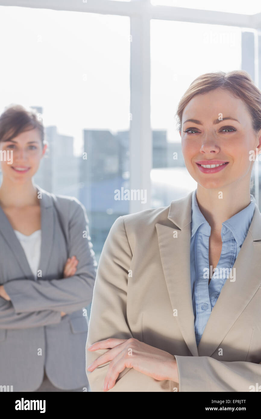 Happy businesswomen with arms crossed smiling at camera Stock Photo - Alamy