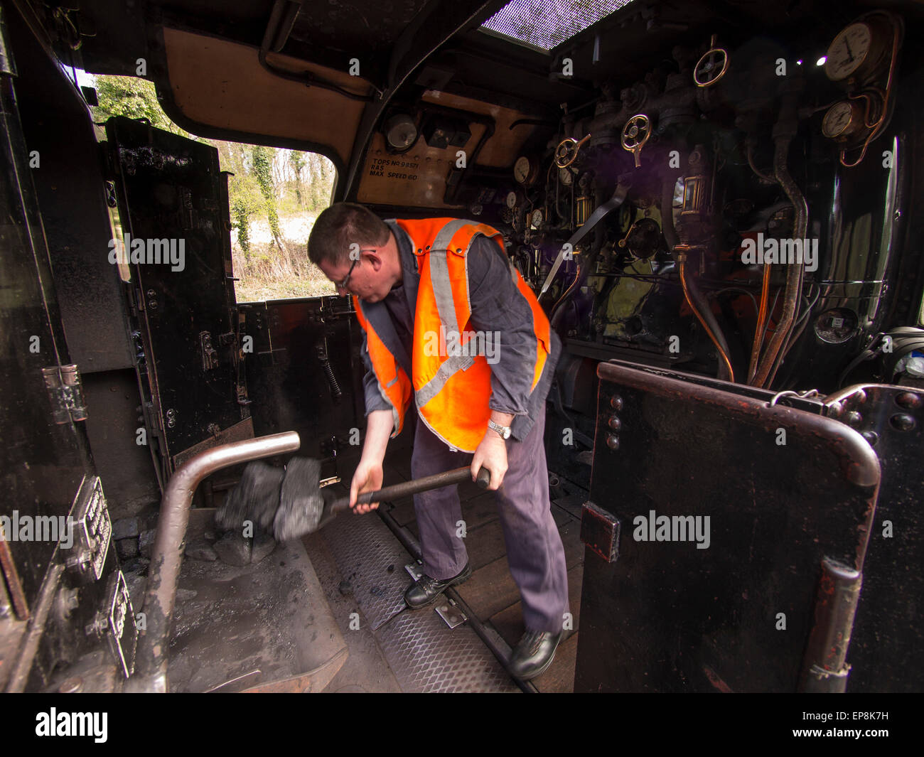 train driver climbs on board steam at Grosmont station,on