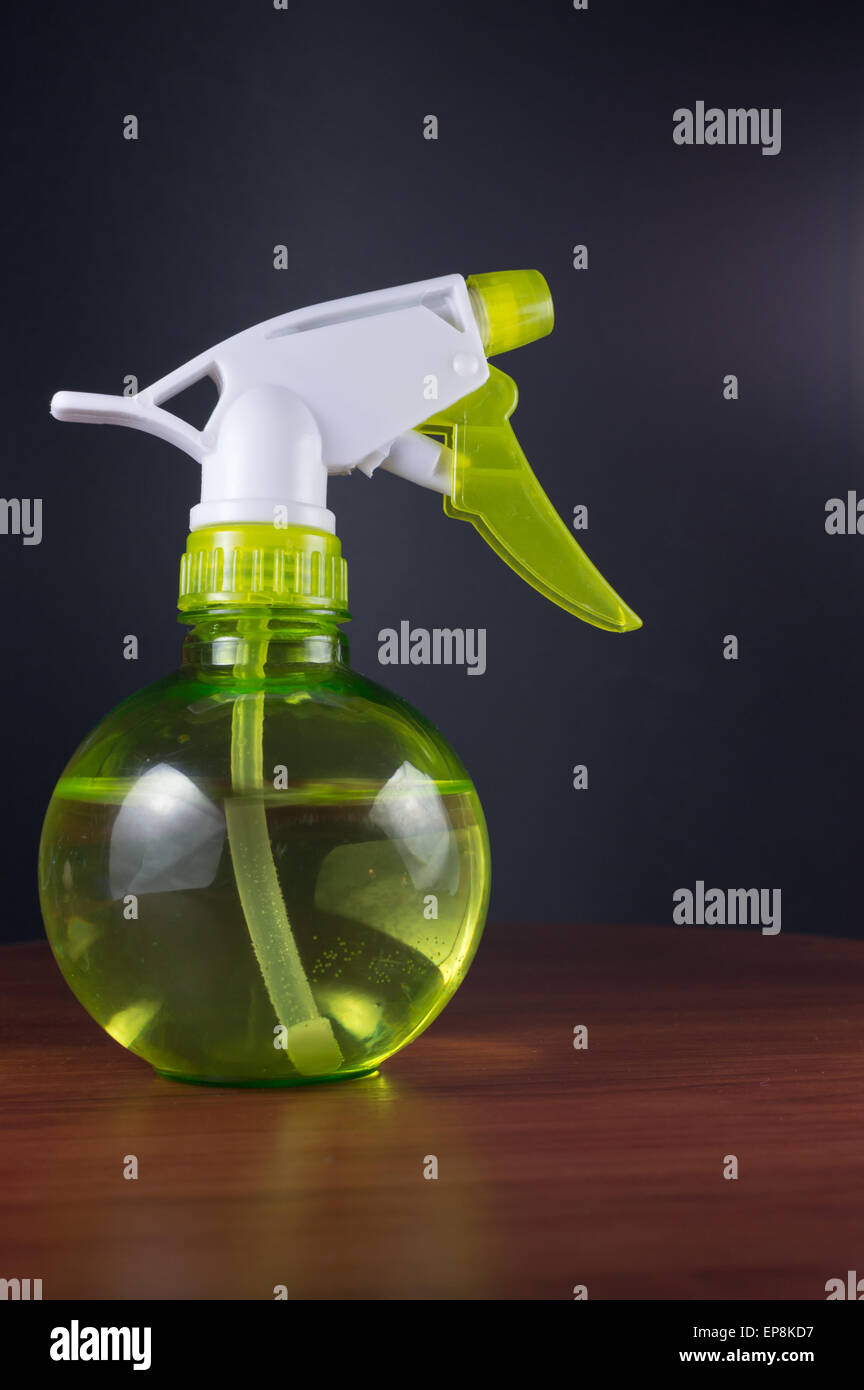 Green bottled water mister on wood with black background Stock Photo