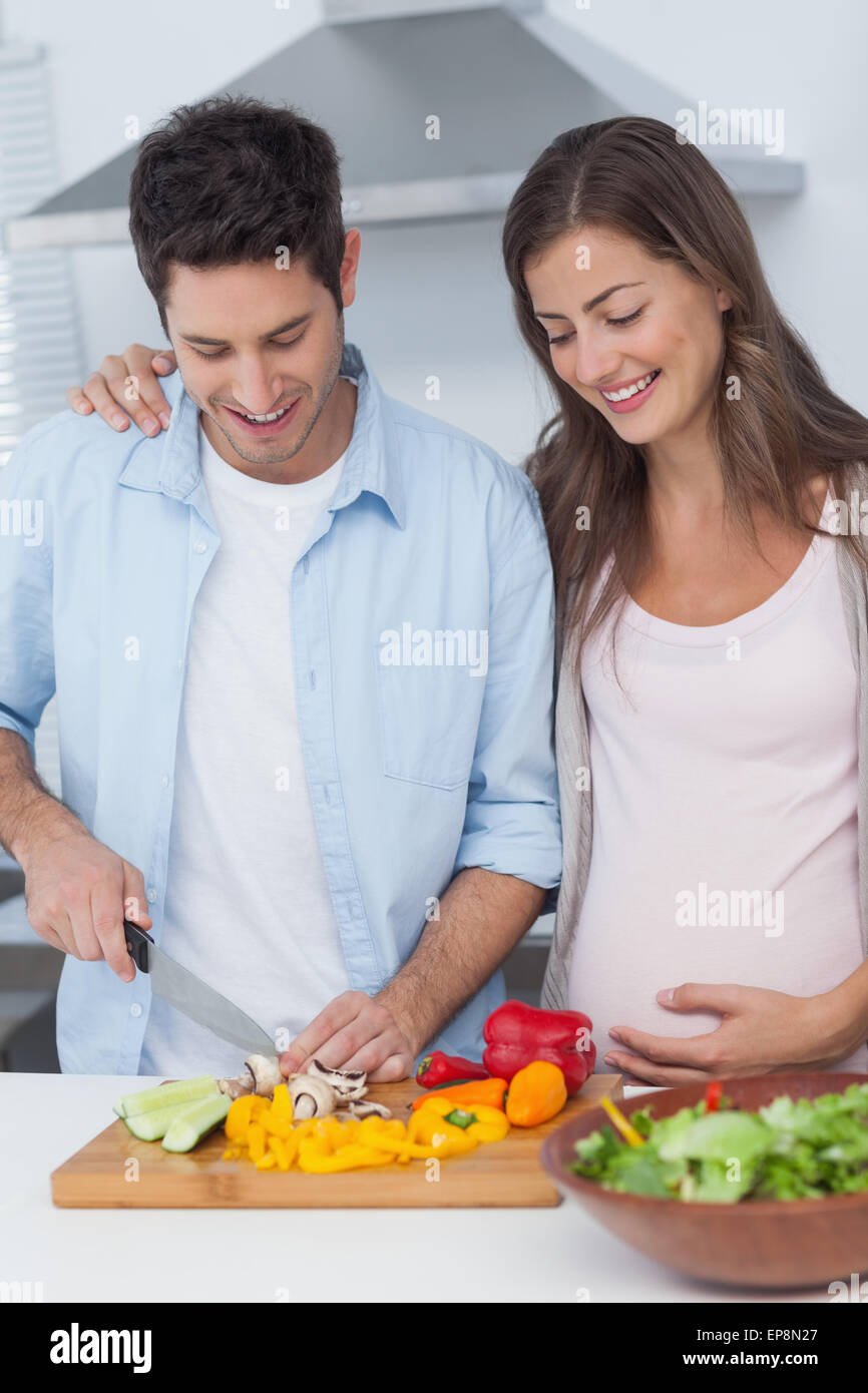 Pregnant woman looking at husband cutting vegetables Stock Photo Alamy