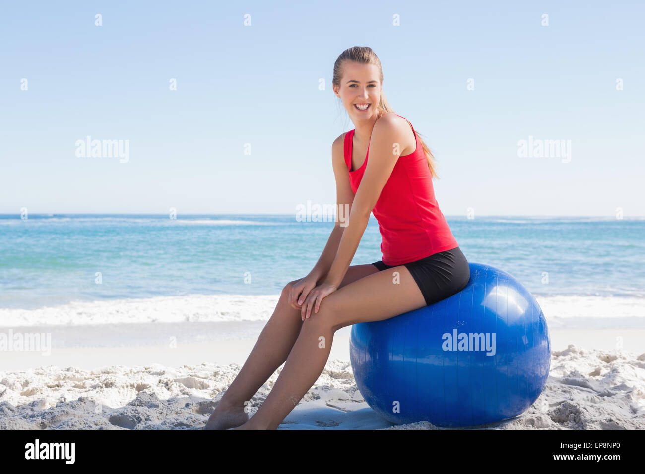 Athletic young woman sitting on exercise ball looking at camera Stock ...