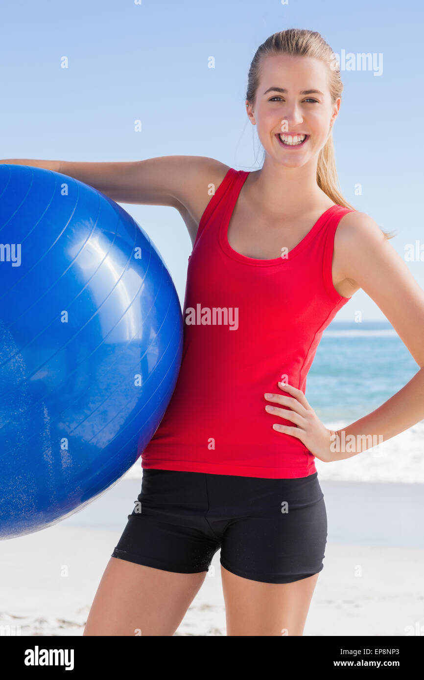 Fit woman holding exercise ball smiling at camera Stock Photo - Alamy