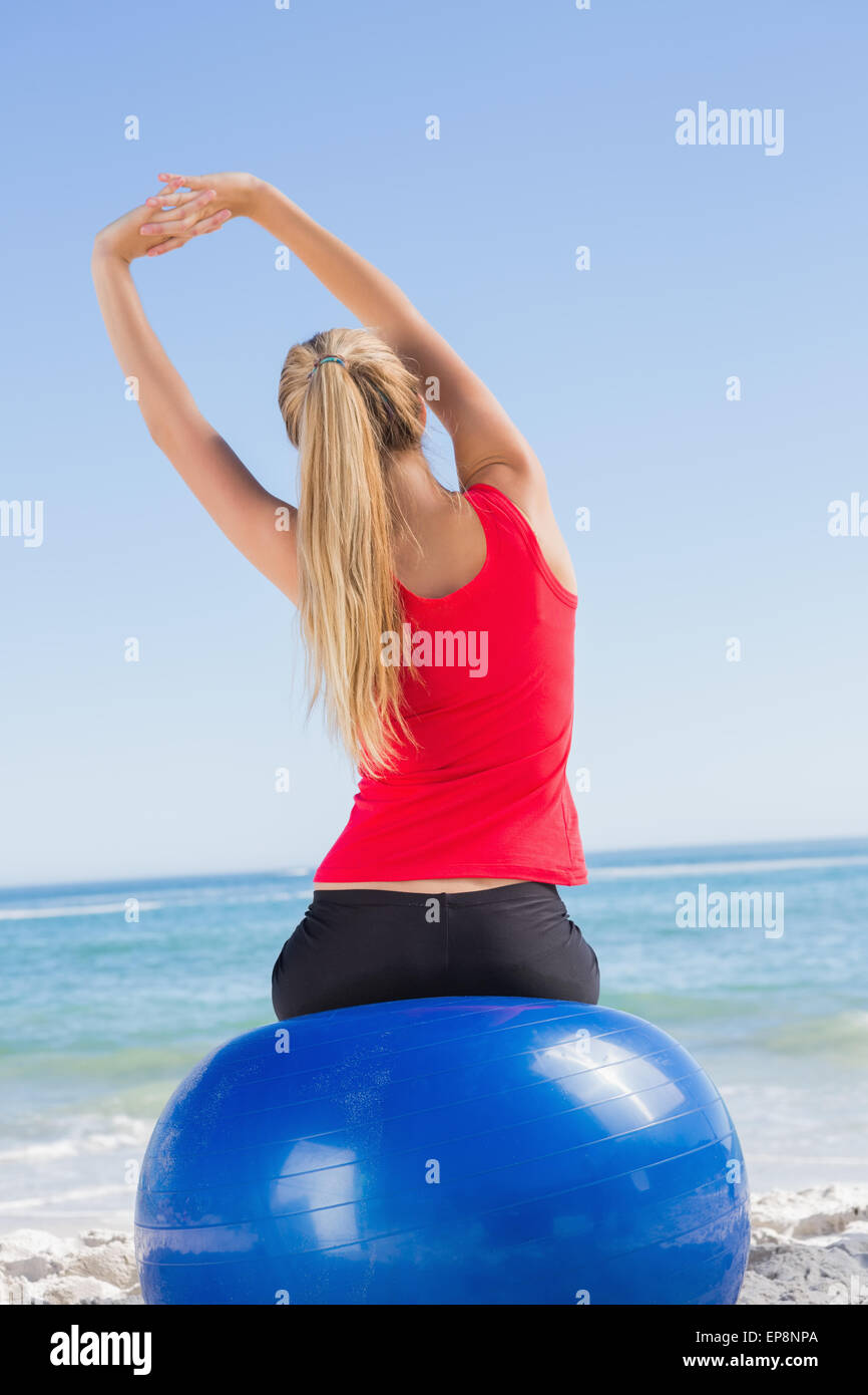 Fit woman sitting on exercise ball looking at sea Stock Photo - Alamy