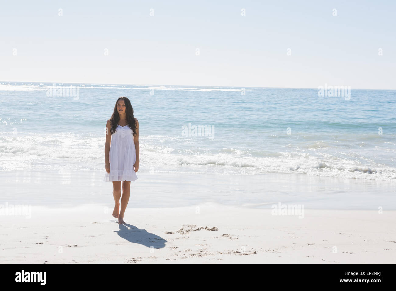 Brunette in white sun dress walking from the sea Stock Photo - Alamy