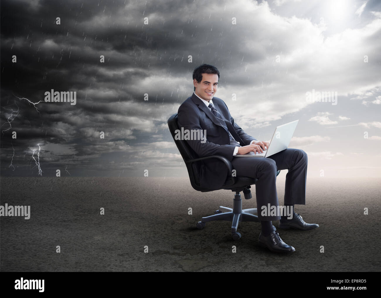Attractive businessman using his laptop outside during stormy weather ...