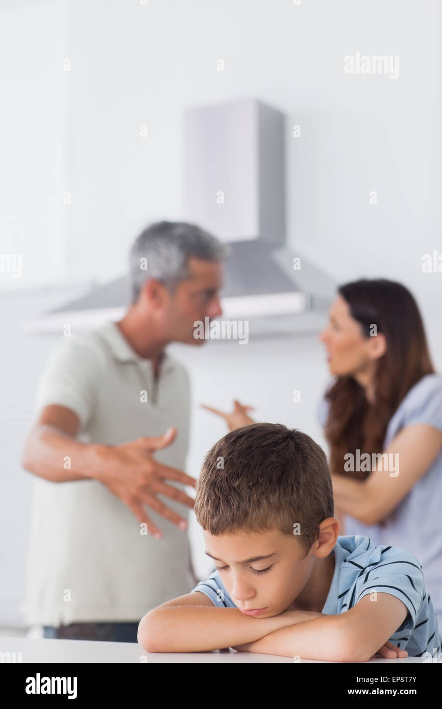 Couple having dispute in front of their sad son Stock Photo